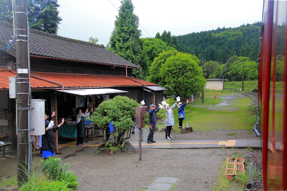 Leaving Masaki station the shop team waives good-bye to the train. (2016)