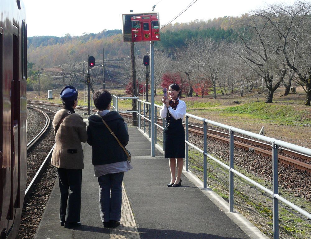 At Okoba station the train attendant takes photographs of the passengers. (2010)